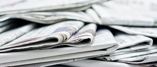 Mehrere Zeitungen mit Presseberichten liegen gefaltet aufeinander