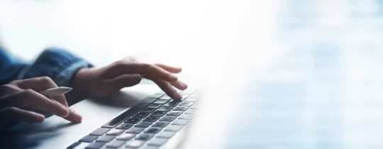 Jemand tippt auf einer Notebook-Tastatur